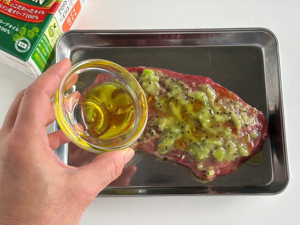 キウイをすりおろす。牛肉にキウイのすりおろしとオリーブオイルの半量をまんべんなくまぶしつける。1時間ほど漬け込んでおく。