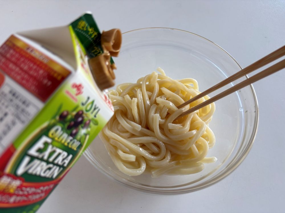 冷凍うどんは袋の表記通りに電子レンジで温め、すぐに水洗いして冷ます。水けをよくきり、ボウルに入れてエクストラバージンオリーブオイル(分量外)を回しかける。よく混ぜてうどんをほぐす。