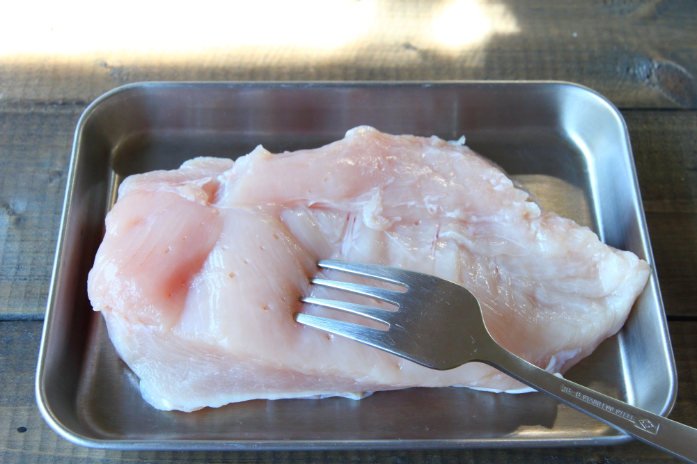 鶏むね肉は厚みのある部分をフォークで刺して穴を開け、火通りをよくする。