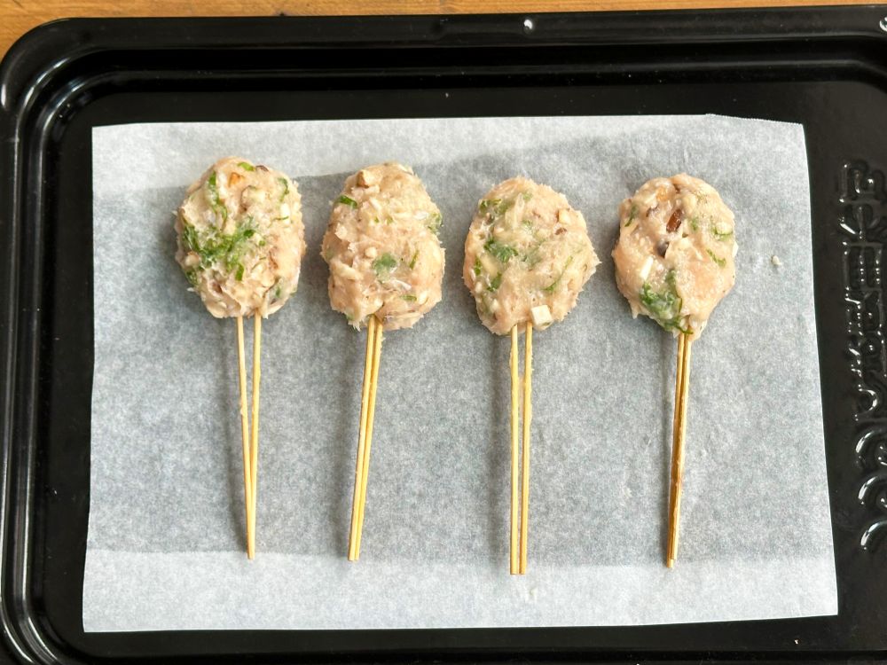 竹串(2本1組)に②を4等分の小判形に丸めて刺すようにして成形し、クッキングシートを敷いた天板に並べる。
