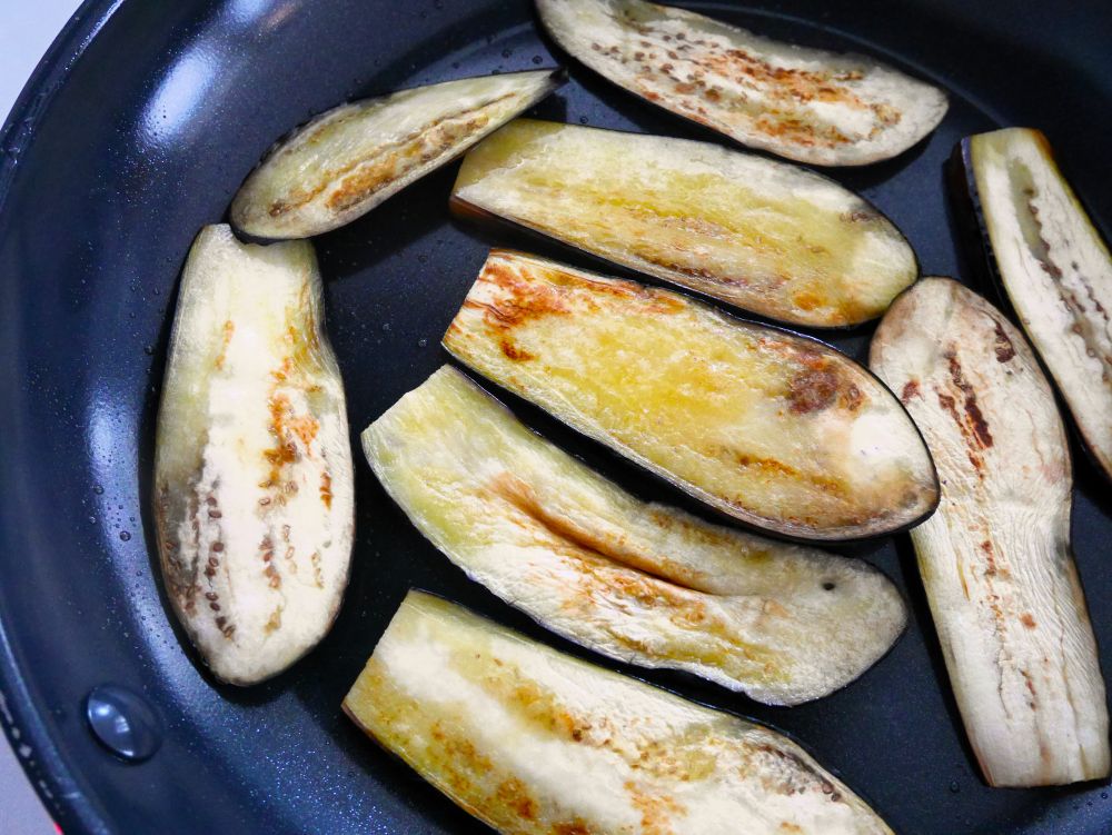 フライパンにオリーブオイルを入れ、弱めの中火で熱し、なすを並べる。両面にこんがりと焼き色がつくまで焼く。