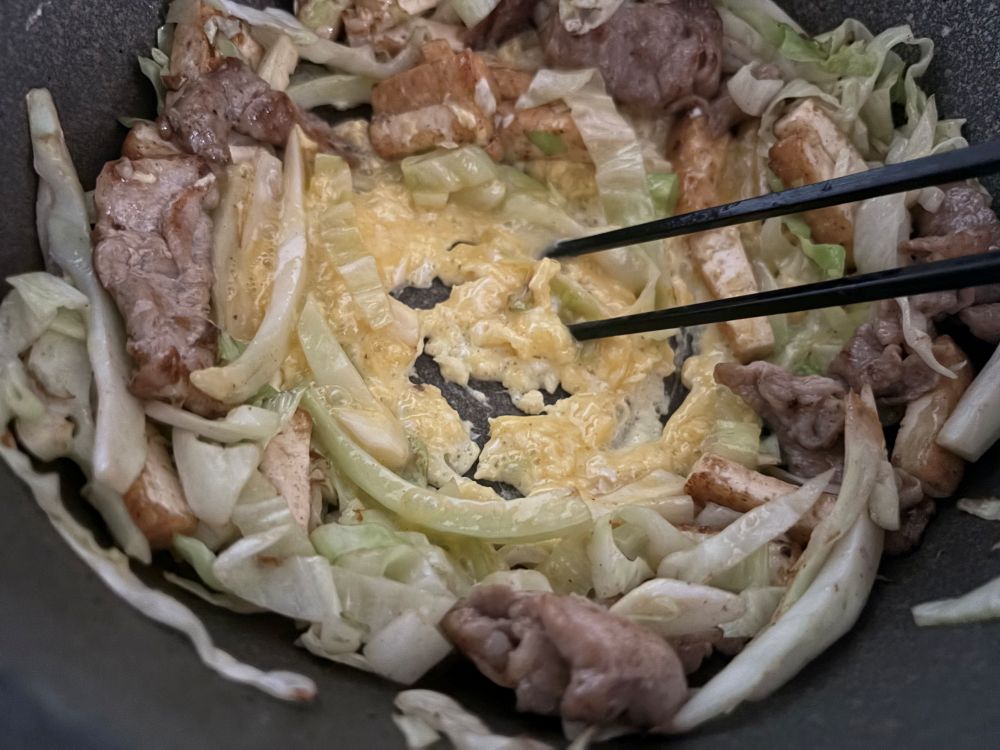 フライパンにオリーブオイルを中火で熱して豚肉を炒め、全体に色が変わったら厚揚げを加えて炒め、さらにキャベツを加えて炒め合わせる。フライパンの中央を空けるようにして具をまわりに寄せ、卵液を流し入れ、炒り卵を作る。