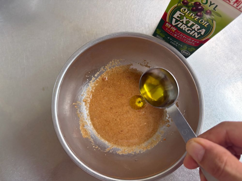 小さめのボウルに（a）の材料を入れ、鶏ささ身の蒸し汁大さじ1を加えて混ぜる。オリーブオイルを加え、さらによく混ぜる。